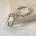 Eleganti orecchini a cerchio incrociati argentati con zirconi splendenti e luminosi. - Stile Linee Incrociate Argentato