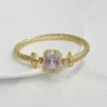 Primo piano del bracciale dorato con dettaglio in zircone rettangolare brillante. - Bianco Oro