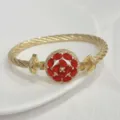 Detailed view of 18k gold plated cable twist bangle bracelet with vibrant red zirconia stone. - G Red