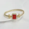Close-up detail of the vintage gold cable bracelet featuring a striking rectangular red gemstone. - Gold Red