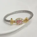Close-up of the pink cubic zirconia cable bangle, showcasing the gold plated twisted wire detail. - Silver Pink