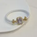 Vista dettagliata di bracciale intrecciato in pelle bianca zircone placcato oro. - Bianco