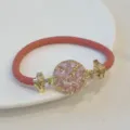 Pink braided leather bracelet with 18k gold plated round pink cubic zirconia clasp detail. - Pink