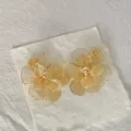 Vista ravvicinata dettagliata di orecchini a fiore in acciaio inossidabile bagnato in oro 18K. - Stile Petalo Traforato Oro 18K (3)