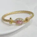 Luxury 18K gold plated twisted cable cuff bracelet featuring a sparkling oval pink cubic zirconia center. - Gold Pink
