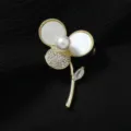 Elegante goldene Blumenbrosche mit Perle und Strass, perfektes Accessoire für Pullover. - Klee