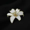 Nahaufnahme der eleganten weissen Blumenbrosche mit goldenem Rand und Kristalldetails. - Pfingstrose