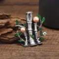 Detailed view of a vintage bamboo pearl brooch with green enamel leaves, elegant jewelry piece. - Bamboo Champagne Pearl