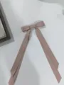 Detalle de una pinza para el pelo con lazo de cinta rosa de doble capa y tiras. - Rosa