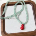 Detailed view of the green aventurine jade bead necklace featuring a vibrant red gourd pendant. - Necklace (5.22-2) / 6mm Bead Necklace / Green