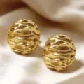 Close-up detail shot of vintage textured gold stud earrings, showing unique metallic surface. - Gold