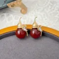 Red agate gourd stud earrings detail shot, vintage style jewelry closeup display on tray. - Red Agate