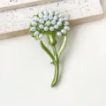 Detailed close-up of the elegant green enamel flower brooch featuring clustered faux pearl beads. - Dandelion Brooch