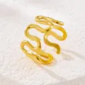 Primo piano dell'anello ondulato dorato con dettagli curvi e una splendida finitura metallica. - Oro
