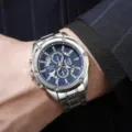 Gedetailleerd overzicht heren quartz horloge met blauwe chronograaf wijzerplaat en zilveren band. - Zilver en Blauw