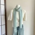 Hellgrüner Strickschal Detailansicht, weiche Wolltextur, elegantes einfarbiges Accessoire. - Bohnengrün
