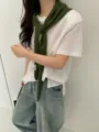Detailed shot of a stylish dark green knit scarf draped over a white t-shirt and jeans. - Avocado Green