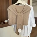 Beige gebreide omslagdoek gecombineerd met wit shirt, stijlvol herfstaccessoire. - Havermout