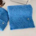 Detalle de conjunto de bufanda y gorro de punto azul, textura suave y peluda, moda de invierno. - Azul (bufanda)