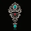 Close-up of vintage baroque brooch, ornate gold-tone metal with green and red crystal rhinestones. - Abstract Pattern Antique Gold Style / Antique Gold
