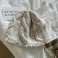 Detail view of the warm wool cable knit beanie hat with cute fringe and cozy texture. - M (56-58cm) / Beige