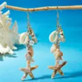 Close-up of beach-style shell and starfish drop earrings on ocean blue background - Starfish Turtle Conch Silver Pendant (5)