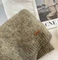 Alpaca Mischung Strickschal Detailansicht mit weicher Textur und Lederetikett Markenzeichen. - Floral Khaki