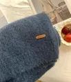 Kuschelweicher, blauer Strickschal im Detail mit dekorativem Lederetikett für den Winter. - Denim-Blau
