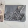 Grauer Winter Schal Detailansicht mit weichem Kaschmirgefuehl und elegantem Fransenrand. - Mittelgrau