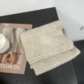 Gros plan détaillé d'une écharpe d'hiver douillette en maille tressée, texture douce, pliée. - Beige