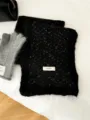 Black fuzzy knit scarf detail with brand tag and matched gloves on clean white bedding background. - Starry Black