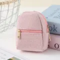 Detailed close-up of a sparkly pink mini backpack coin purse with golden zippers. - Pink