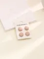 Gros plan détaillé des fermoirs aimantés ronds roses mats pour hijab, texture très délicate. - Chair