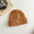 Children knit beanie hat detail view, brown winter cute heart embroidery wool cap closeup. - Ginger Yellow Hat