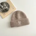Detailansicht einer khakifarbenen Kinder-Wollmütze mit einer niedlichen weißen Herzbestickung. - Khaki Hut