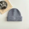 Detaillierte Nahaufnahme einer kuscheligen grauen Kinder Strickmütze mit süßer Herzstickerei. - Grau Mütze