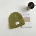 Vista detallada de la textura del gorro de punto verde, accesorio de sombrero de invierno cálido. - Gorro verde fruta