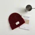 Detalle de gorro de punto rojo, cálido gorro de invierno de mezcla de lana suave con etiqueta. - Gorro Burdeos