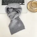 Grey knit scarf detail showing cute white heart embroidery, soft winter accessory close-up - Grey Scarf