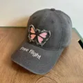 Nahaufnahme der Destroyed Jeans Baseballcap mit rosa Schmetterlingsstickerei und Textdetail. - M (56-58cm Verstellbar) / Rosa Schmetterling Stickerei / Dunkelgrau