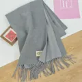 Nahaufnahme eines grauen Kaschmir-Gefühl Winterschals mit feiner Textur und Fransensaum. - 68x200cm / Mittelgrau
