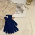 Vista detallada de acogedores guantes de punto azul exhibidos con accesorios elegantes. - Talla única / Azul Zafiro