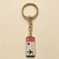 Close-up of the travel ticket design metal keychain pendant with airplane charm detail. - Pink Ticket