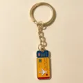 Closeup of the travel ticket metal keychain with airplane and adventure awaits text detail. - Blue Ticket