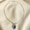 Collier ton argent avec chaîne florale délicate et pendentif hibou en cristal bleu. - Bleu saphir