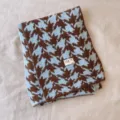 Detailansicht eines stilvollen blau-braunen Hahnentritt-Kniestrickschals für Damen und Herren. - Hahnentritt Blau