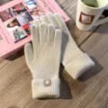 Detailaufnahme gemütlicher beigefarbener Strickhandschuhe mit Bündchen auf Holzmaserung. - Einheitsgröße / Beige