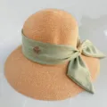 Vue détaillée d'un chapeau de paille d'été avec un ruban vert et un logo métallique. - M (56-58cm) / Vert Feuille Morte avec Nœud