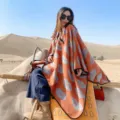 Mujer estilo étnico capa chal naranja con patrón, cálido invierno viaje desierto fotografía. - Estampado de labios naranja