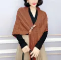 Detailed view of the women's brown knitted shawl cape with leather buckle and stylish design. - 70-180CM / Caramel color